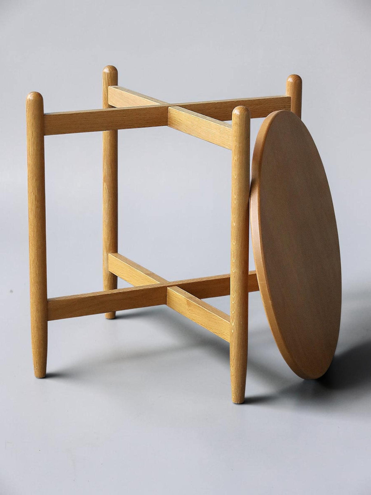 Rundt dansk vintage sidebord i massiv brun eg med skulpturelt krydsstel